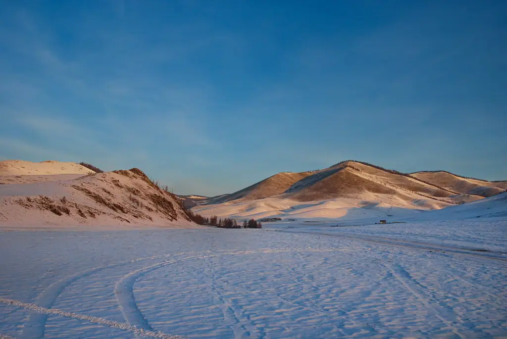 Snow-covered hills glowing at sunrise